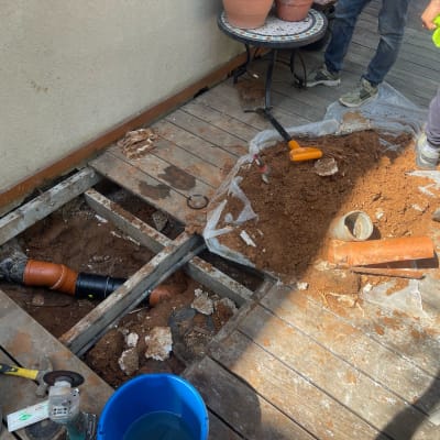 עבודות תיקון צנרת על רצפת עץ עם כלי עבודה