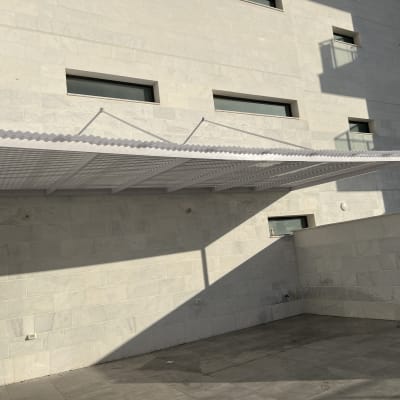 פרגולה מאלומיניום מותקנת על קיר חיצוני