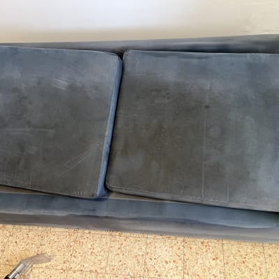 ספה עם כתמים וכלי ניקוי על הרצפה