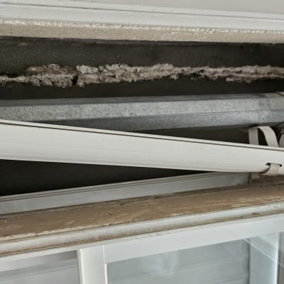 תריסים לבנים עם מנגנון גלילה חשוף