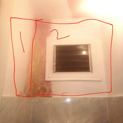 קיר עם סימני רטיבות ליד חלון קטן