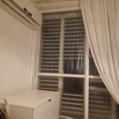 חלון עם תריסים ומזגן בחדר