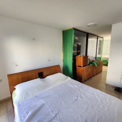 חדר עם קיר לבן, רהיטים מכוסים בניילון ירוק