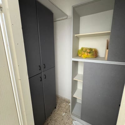 ארון אפור עם מדפים וחפצים בתוכו