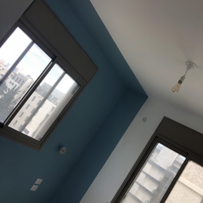 קיר צבוע בכחול עם סולם צביעה בחדר