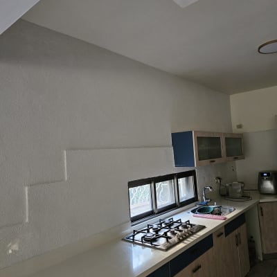 קיר צבוע בלבן עם מרקם מחוספס במטבח