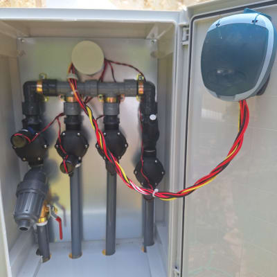 מערכת השקיה עם צינורות ושסתומים בגינה