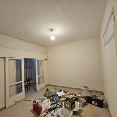 חדר עם ציוד לצביעה, כולל דלי צבע וכלי עבודה