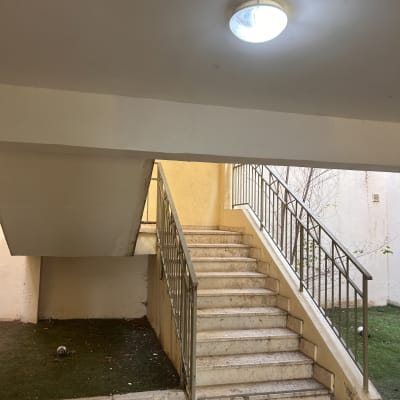 גרם מדרגות עם מעקה מתכת ותאורה עליונה