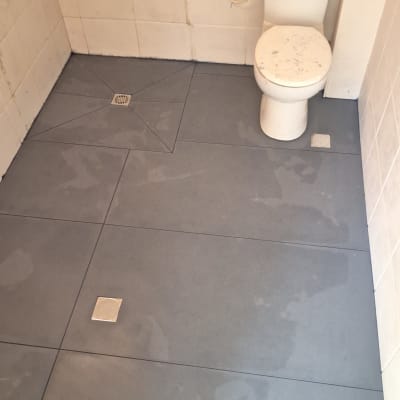 רצפת חדר אמבטיה עם אריחים חדשים ואסלה