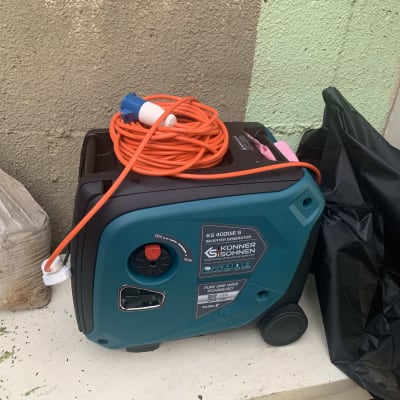 גנרטור כחול עם כבל חשמל כתום מלופף