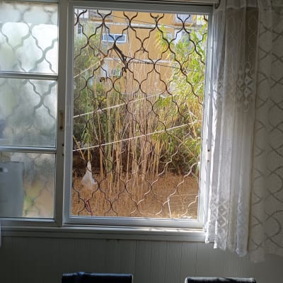 חלון עם סורגים ודלת זכוכית שקופה למחצה