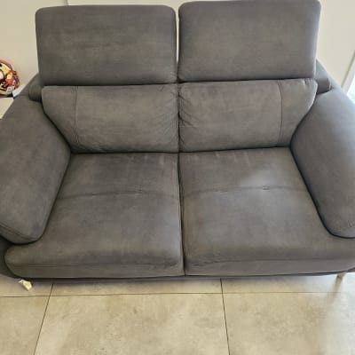 ספה אפורה נקייה על רצפת אריחים בהירה