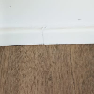 חיבור בין קיר לרצפת עץ עם סדק