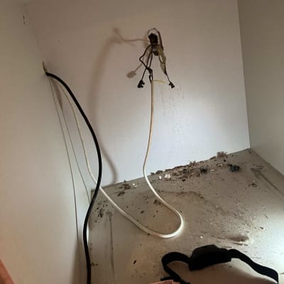 חוטי חשמל חשופים יוצאים מהקיר עם סרט בידוד