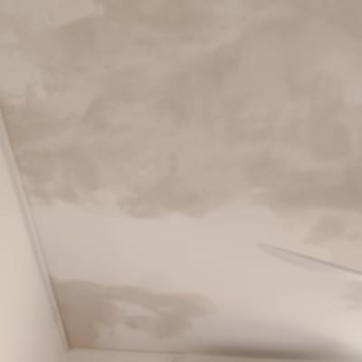 תקרה עם סימני צבע ותיקונים ליד מזגן