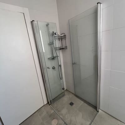 מקלחון זכוכית עם ראש מקלחת ומדף מתכת