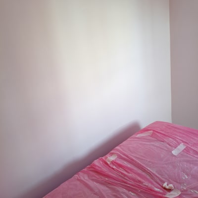 קיר צבוע עם יריעת מגן ורודה על הרצפה