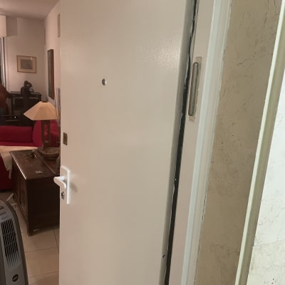 דלת פתוחה עם ידית לבנה ומנעול