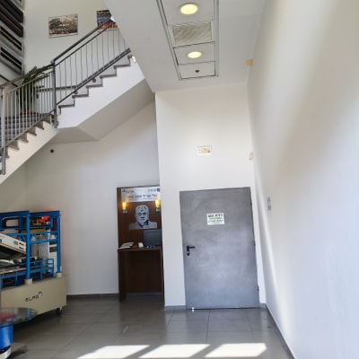 חלל כניסה וגרם מדרגות במבנה מסחרי עם קירות צבועים בלבן