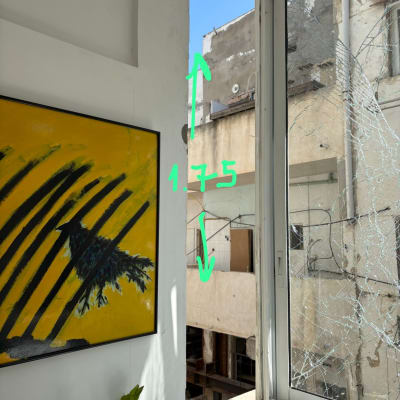 חלון שבור עם סימני מדידה על הקיר