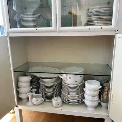 מדף זכוכית בארון עם כלי זכוכית וצלחות