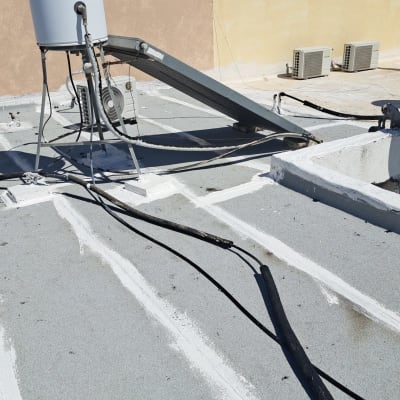 גג עם חומרי איטום, דלי ומברשת