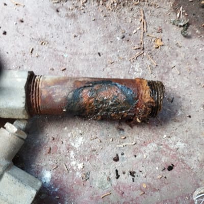 צינור חלוד עם נזקי קורוזיה על הרצפה