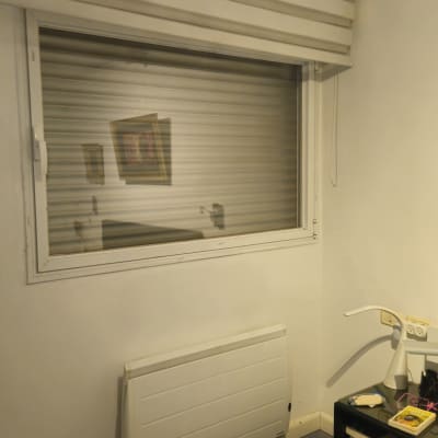 תריסים סגורים על חלון בחדר עם רדיאטור