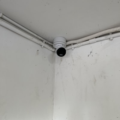מצלמת אבטחה מותקנת בפינת תקרה עם חיווט גלוי