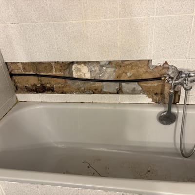 אמבטיה עם קיר פתוח וצנרת חשופה