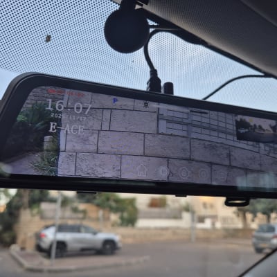 מראה אחורית עם מצלמה ברכב, מציגה תמונה של חניה