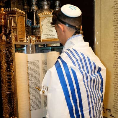 נער קורא בתורה עם טלית ותפילין