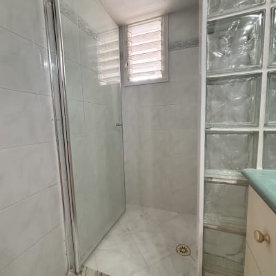 מקלחון עם קירות זכוכית ורצפת קרמיקה