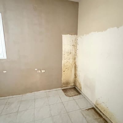 קיר עם סימני רטיבות ועובש בחדר ריק