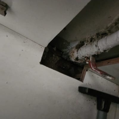 צינור עם סימני נזילה בארון מתחת לכיור