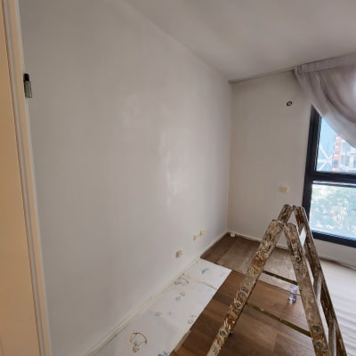 קיר צבוע בלבן עם סולם ומגן רצפה