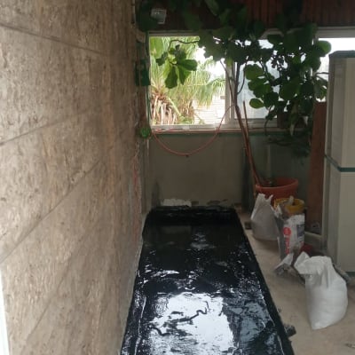 משטח אטום בזפת שחורה עם שקי חומרי בנייה