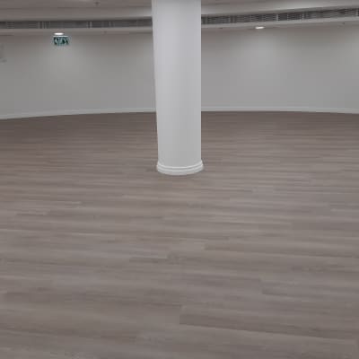 רצפת פרקט עץ חום בחדר ריק עם עמוד לבן