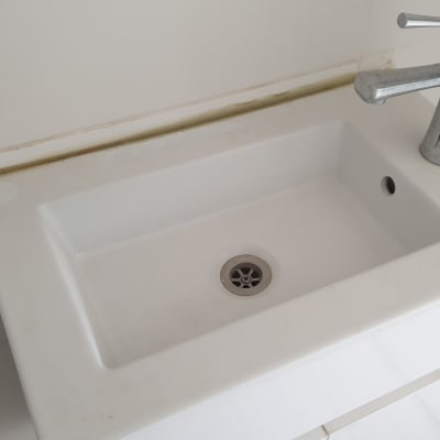 כיור לבן עם ברז מתכת כסוף