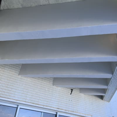 קורות בטון צבועות בלבן על קיר חיצוני