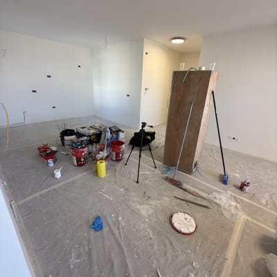 חדר ריק בתהליך צביעה עם ציוד צביעה ורצפה מוגנת