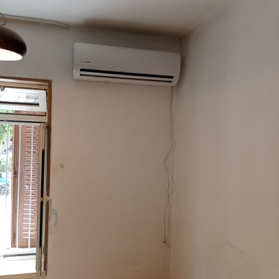 מזגן מותקן על קיר עם כבל חשמל גלוי