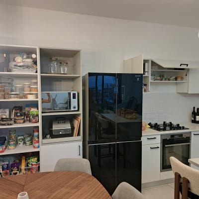 מטבח מאורגן עם מדפים מלאים במצרכים וכלים.