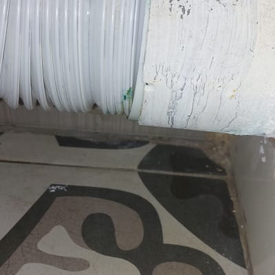 צינור לבן עם סימני שחיקה על רקע רצפה מעוצבת