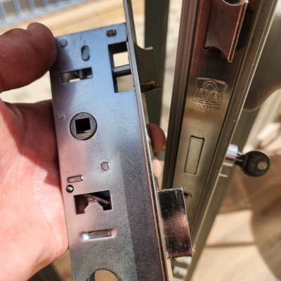 מנעול מתכת ביד של מנעולן ליד דלת