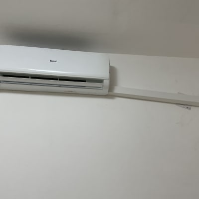 מזגן קיר לבן מותקן על קיר עם צינור חיבור