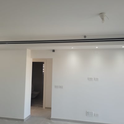 פתח מיזוג אוויר בתקרה לבנה עם תאורה שקועה