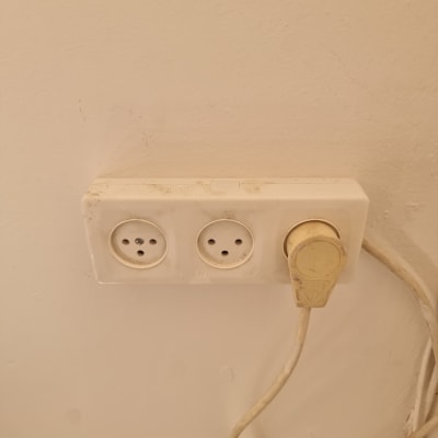 שקע חשמל עם תקע מחובר לקיר