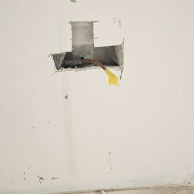 קיר עם חור ותשתית חשמל חשופה